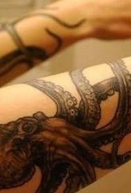 Patronat de tatuatge de polp de color gris negre de realisme al braç