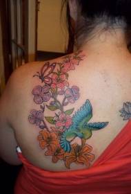 Colorful hummingbird and flower tattoo on shoulder