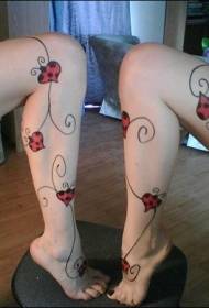 Mergaitės kojos širdies formos ladybug ir vynuogių tatuiruotės modelis