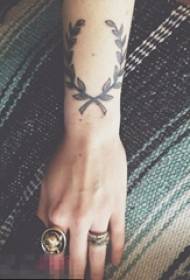Krahu i vajzës në materialin e bimëve të zeza me gjemba foto tatuazhi me gjethe