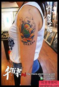 Девојка за руку прелепог обојеног традиционалног узорка тетоваже лотоса