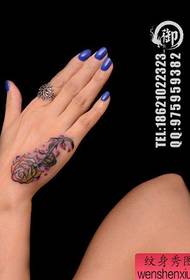 Female hand pops beautiful rose tattoo pattern