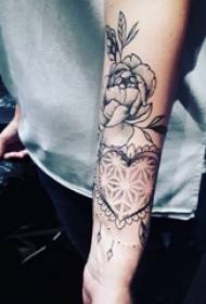 Djevojačka ruka na crno sivoj skici kreativni oblik srca i cvjetna tetovaža slike