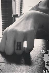 H character tattoo pattern on the finger