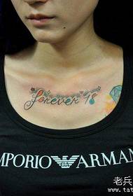 Meitenes krūtīs skaists angļu valodas alfabēta tetovējums