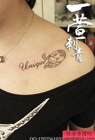 在女孩的鎖骨上的美麗女性字母和貓紋身