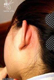 Fluorescent English tattoo pattern behind the ear