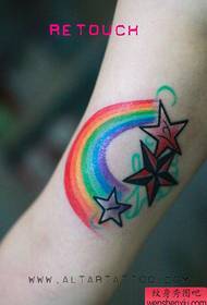 Girl's arm inside rainbow five-pointed star tattoo pattern