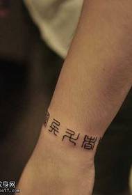 Rokrakstā rakstīts ķīniešu rakstu zīmes tetovējums