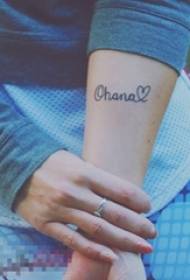 Tyttö käsivarsi mustilla geometrisilla viivoilla Englannin kielen sanat ja sydämenmuotoiset tatuointikuvat