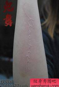 Tatuiruotės raštas ant vienos rankos baltos raidės