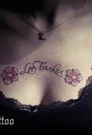 Schöne kleine Kirschblüten-Alphabet-Tätowierung auf der Brust des Mädchens