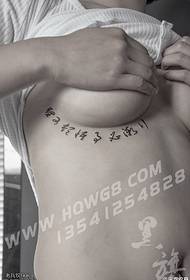 Kinesiskt tatueringsmönster under bröstet