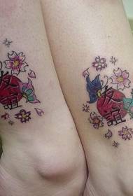 moteriškos kojos japoniško stiliaus simbolis su gėlių tatuiruote