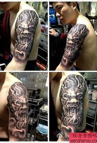 brazo masculino dominante patrón de tatuaje de cabeza de dragón super guapo