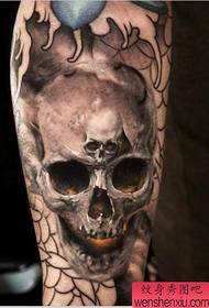 a horrible skull tattoo on the arm