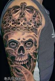 big arm wearing a crown skull tattoo pattern