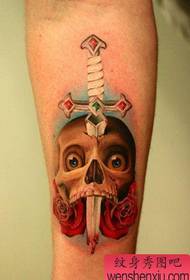 vyriškos rankos dominuojantis klasikinis durklo ir kaukolės tatuiruotės modelis