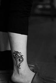 black and white dragon-shaped totem tattoo