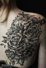 aizmugurē melns pelēks ziedu tetovējums
