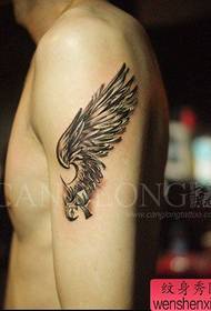 Το αρσενικό βραχίονα φαίνεται καλό στο δημοφιλές μαύρο και άσπρο μοτίβο τατουάζ φτερά