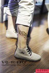 piękny wzór tatuażu z piórkiem lamparta popularny na nodze
