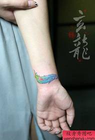Mergaičių riešai yra maži ir gražiai spalvoti plunksnų tatuiruotės dizainai