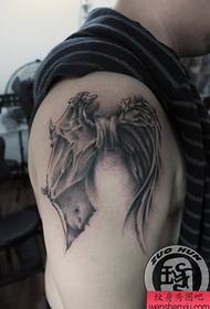 Berniukai ginkluoja tatuiruotės modelį su angelo ir demono sparnais