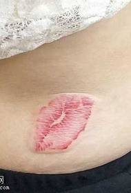 a colorful lip print tattoo at the waist