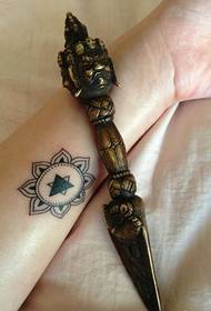 ramię kobiety na małej kobiecej tatuażu Brahma Totem