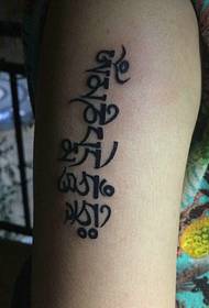 single Sanskrit tattoo pattern on the outside of the arm