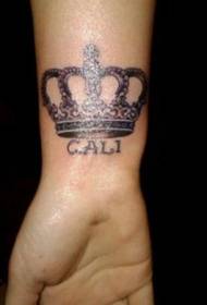 Crown and letter tattoo on wrist