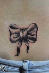 Small bow tattoo on the waist