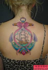 Meitenes mugurā skaists krāsains enkura tetovējums