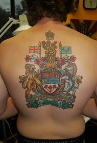 Vahvan miehen vasemman käden iso käsi ja viileä kilpi-muotoinen heraldinen tatuointi