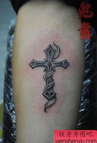 a cross arm tattoo on the inside of the small arm