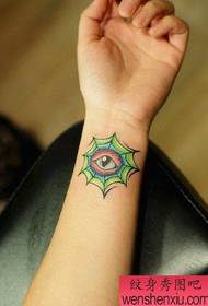 Meitenes roka ar skaistu acu tetovējuma modeli