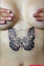 A sexy butterfly tattoo under the chest of a beautiful woman