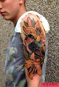 A beautiful lily flower bird tattoo picture on the handsome man's arm