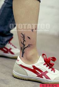 a tree tattoo on the ankle