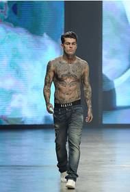 músculo masculino Con jeans fuerte y tatuaje de personalidad