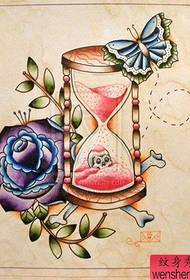 ett manuskriptskarta för rosor i timglas delat av tatueringsshowen