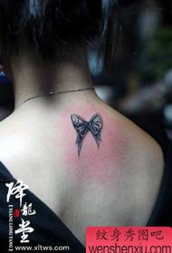 girl's back small and stylish bow tattoo pattern