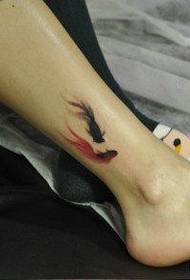 маленький і ніжний малюнок татуювання маленької золотої рибки на ногах дівчини