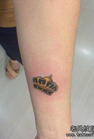 girl's arm colored small crown tattoo pattern