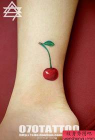 a small and delicate cherry tattoo pattern at the girl's ankle