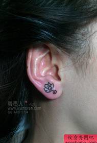 girl ear a small lotus tattoo pattern