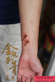 Patrón de tatuaxe sangrante no muñeco do pulso dunha rapaza