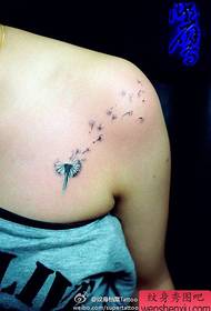 Klein en populair paardenbloem tattoo-patroon op de schouder van het meisje