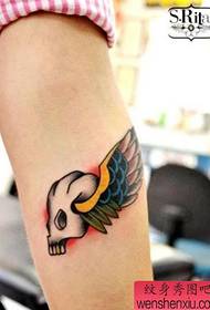 girl's arm with a tattoo and wings tattoo pattern